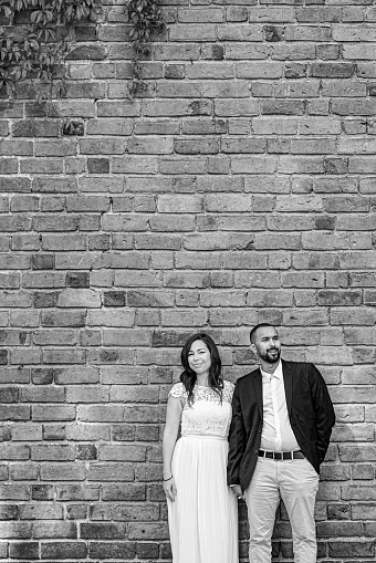 a couple stands in front of a brick building