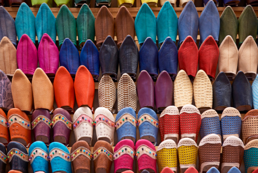 Colorful display of traditional leather slippers for sale in the historic medina of Fes in Morocco.
