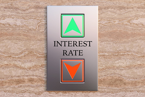 The word INTEREST RATE engraved between up and down lift buttons on a marble wall. Illustration of the concept of fluctuation and forecast of interest rate