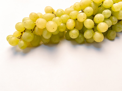 Fresh organic bunch of green grapes on white background with copy space