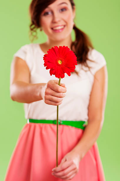 istock Young woman showing a red gerbera 163218600