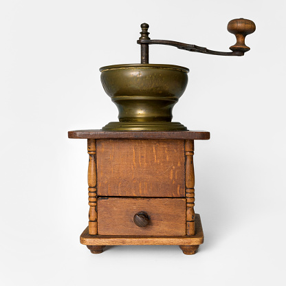 Old wooden coffee mill. On white