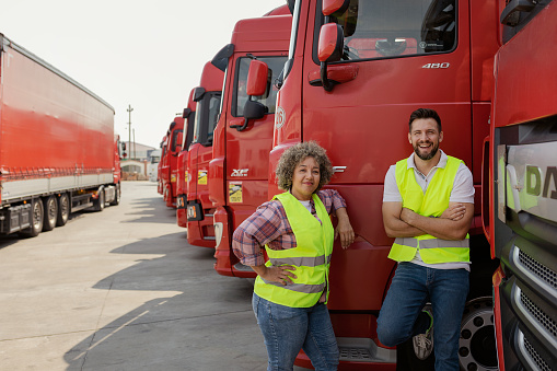 Two Professional Truck Drivers With Transport Truck Looking at Camera. Logistics Worker