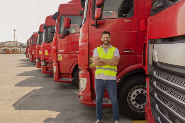 istock Confident Truck Driver on Parking Lot Looking at Camera 1632197665