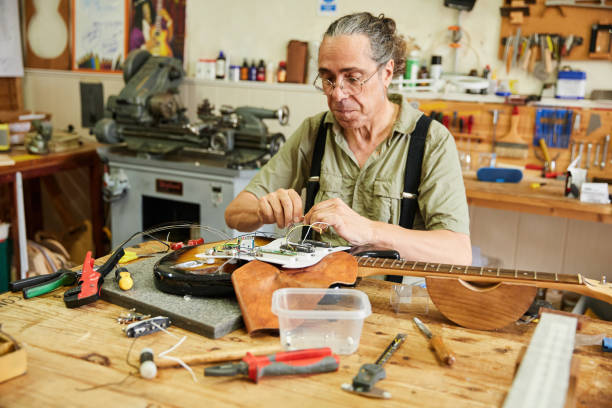 istock Man luthier repairing an electric guitar in his workshop 1632200610