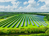 Aerial view of solar panels on green field at suburb in sunny day