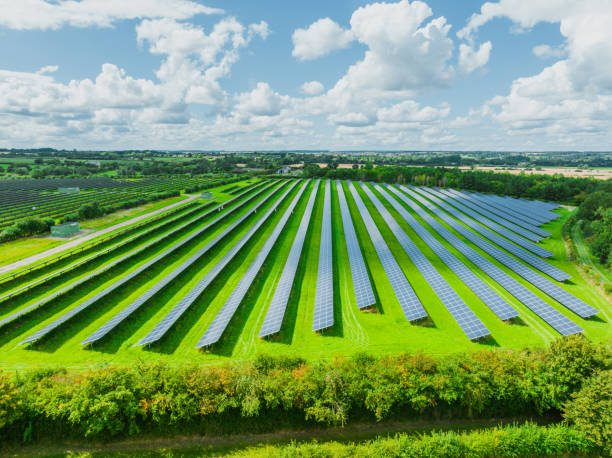 Aerial view of solar panels on green field at suburb in sunny day stock photo