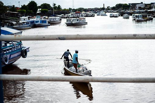 Lungi, Port Loko District, Sierra Leone: airport shuttle - the crew unloads luggage - pier of the Lungi boat terminal, serves shuttle speedboats (Sea Coach Express) and water taxis, offering services for passengers visiting and going out of the country through Lungi international airport, located on the north side of Tagrin Bay, opposite Freetown.