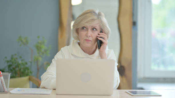 istock Senior Old Woman Talking on Phone for Work 1632274090