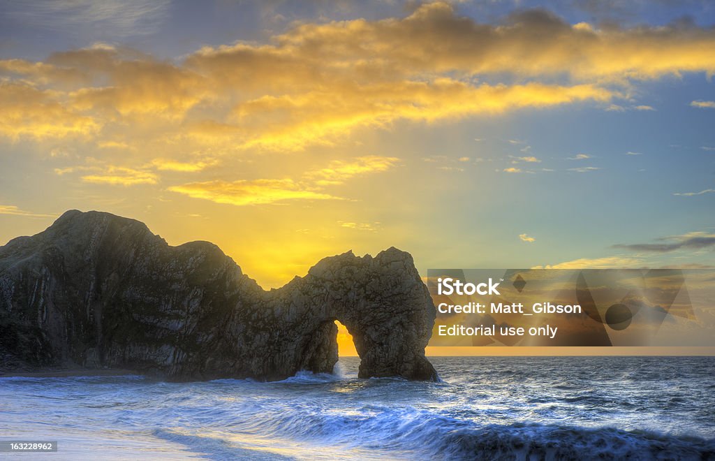 Vibrante nascer do sol sobre o mar com pilha de pedras em primeiro plano - Foto de stock de Beleza natural - Natureza royalty-free