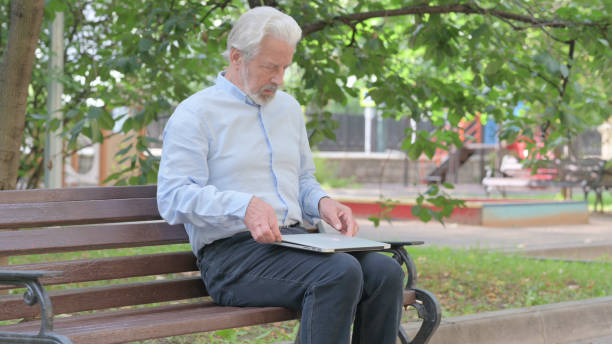 istock Senior Old Man Coming, Sitting on Bench and Working on Laptop 1632369884