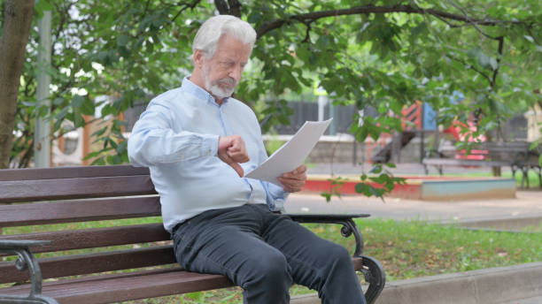 istock Senior Old Man Feeling Upset while Reading Contract Outdoor 1632370431