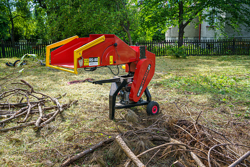 Rzeszów, Subcarpathian, Poland - 31 July 2023: Remet's small mobile diesel wood chipper while working in the garden