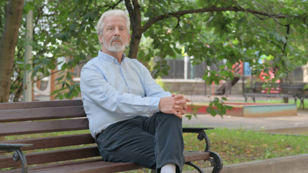 istock Serious Senior Old Man Sitting Outdoor and Looking at Camera 1632377694