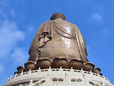 The Great Buddha of Nong Ping, on Lantau Island, in Hong Kong seen by drone on a background of the sea of clouds.
