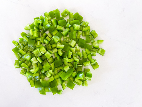 Green bell pepper, chopped, cut into pieces, on a white background