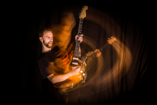 Guitarist playing a screaming guitar solo, with intentional motion blur.  