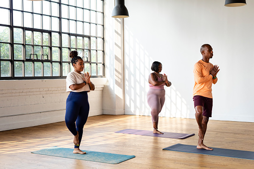 African American men and women participate in tasks centering their mental health and wellbeing such as meditation, yoga, small group conversations with friends and community, repotting plants and journaling