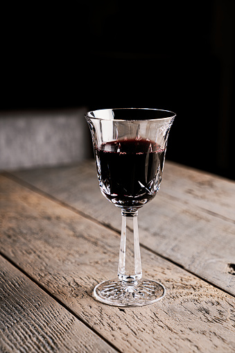 Red wine in a crystal glass on a wooden table