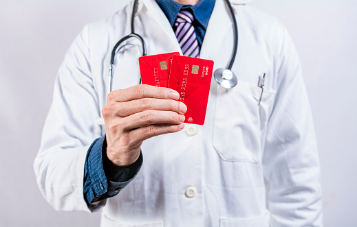Doctor hands holding credit cards. Doctor holding two credit card isolated. Concept of medical card payments