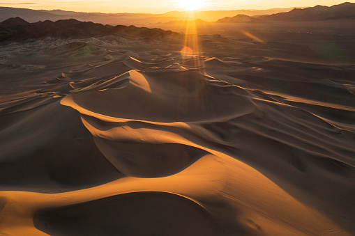 Dramatic desert dune landscape with golden light. Photographed in California over public land.