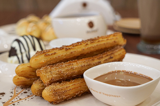 Churros served with ice cream, cream cheese and melted chocolate dip
