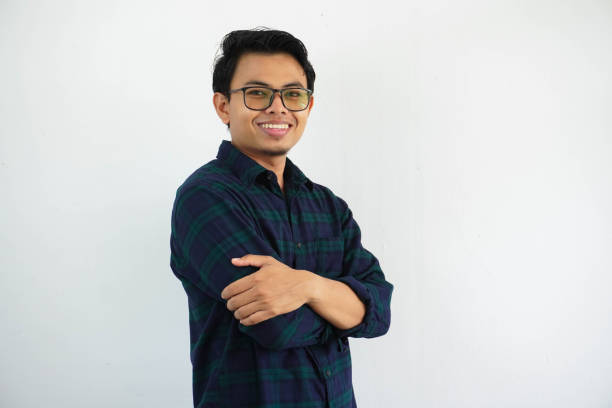 istock smiling young asian man showing happy expression standing confident with arms crossed isolated on white background 1632514217