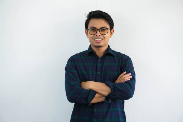 istock smiling young asian man showing happy expression standing confident with arms crossed isolated on white background 1632514477
