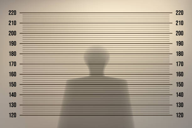 stockillustraties, clipart, cartoons en iconen met mugshot in a police station with a retro background with backlight on an old wall and the shadow of a man - achterdocht