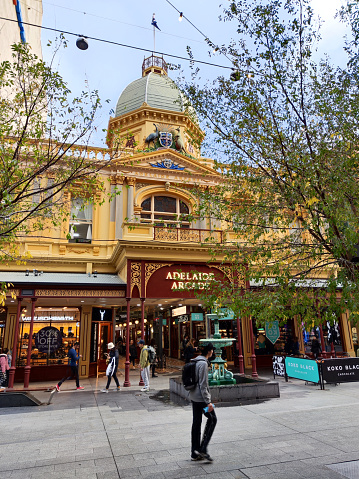 People walking on Rundle mall, at the entrance of Adelaide Arcade, a heritage shopping arcade in the centre of Adelaide, South Australia.