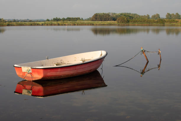 istock Dinghy reflected in calm water at Agernaes, Funen, Denmark 1632560629