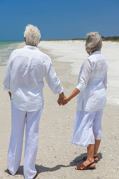 istock Happy Senior Couple Holding Hands on Tropical Beach 163257561
