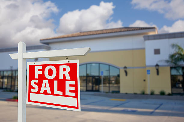 Vacant Retail Building with For Sale Real Estate Sign stock photo