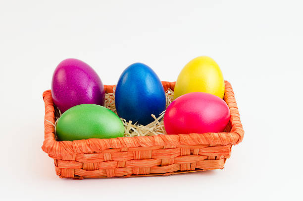 Five colored easter eggs in orange basket stock photo
