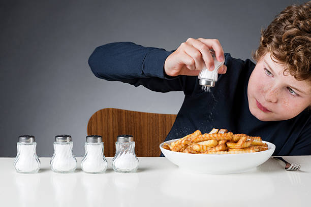 jovem rapaz com excesso de sal - smashed potatoes imagens e fotografias de stock