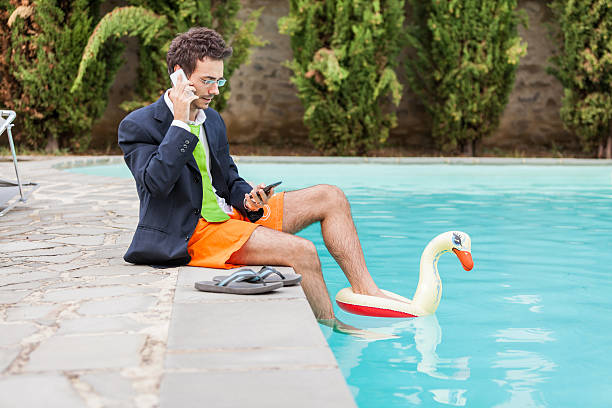 istock A young businessman taking a call by the pool 163258872