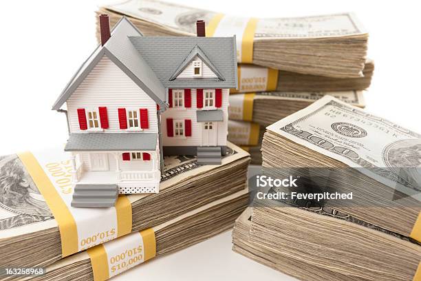 Hundreds Of Dollars Stacked With Small House Stock Photo - Download Image Now - Business, Corporate Business, Currency