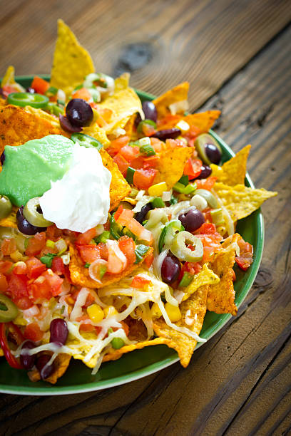istock Fully loaded nachos in a green plate on a wooden table 163260775