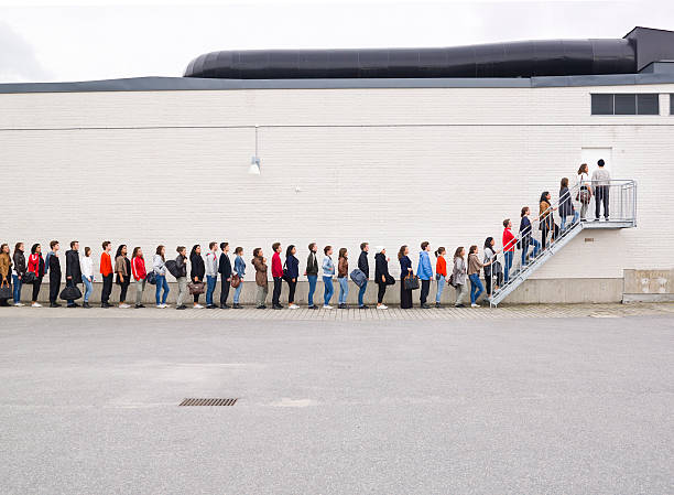 Waiting in LIne Large group of people waiting in line people in a line stock pictures, royalty-free photos & images