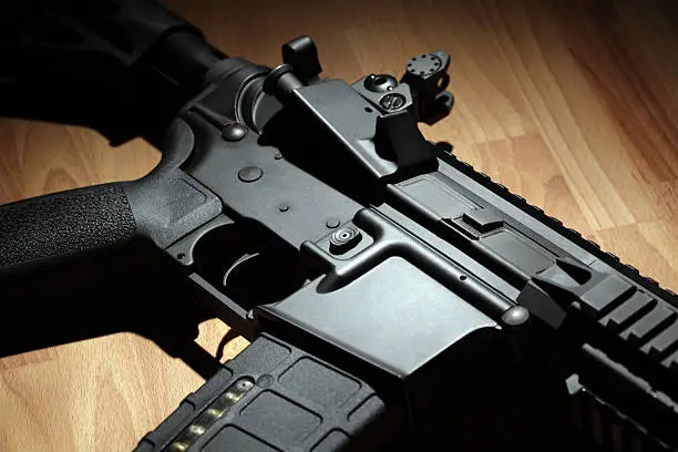 Part of AR-15 (M4A1) carbine in a light beam