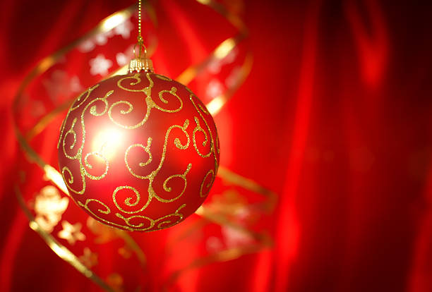 Red christmas ball with ribbon on background