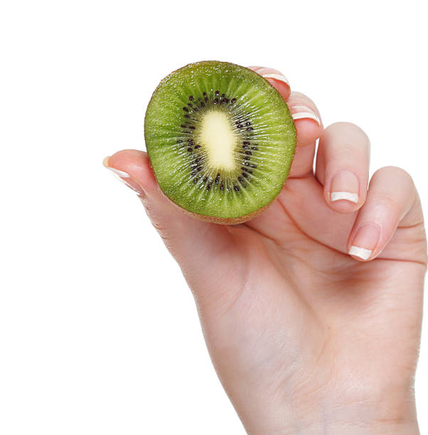 istock woman hand with kiwi fruit isolated 163267396