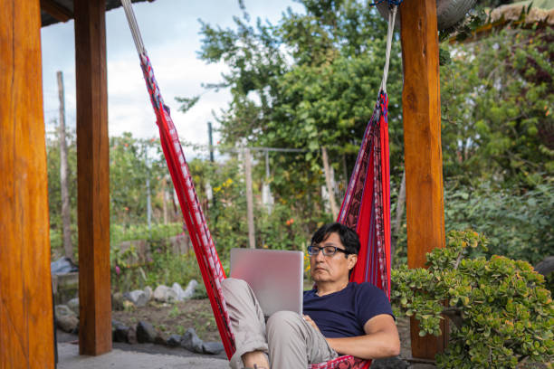 istock Man in a garden working in a hammock 1632699913