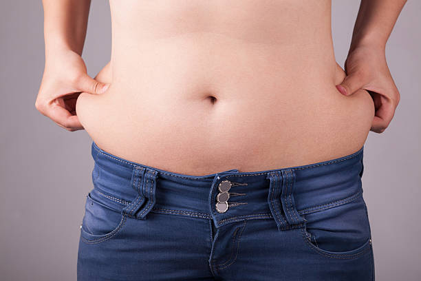 übergewichtige frau halten fett bauch - pot belly stock-fotos und bilder