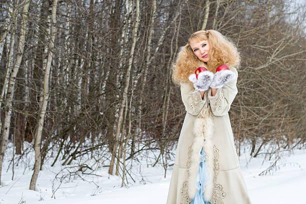 A woman is having a wonderful time on a Sunday afternoon. She's enjoying the holiday magic to the fullest, spending time outdoors in spite of coldness.