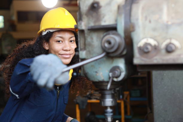 istock Technician engineer or worker woman in protective suit smiling and looking at camera maintenance operation or checking lathe metal machine at heavy industry manufacturing factory. Metalworking concept 1632782708