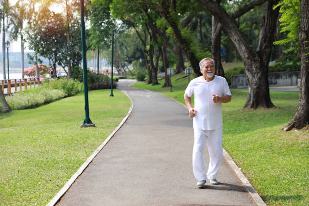 istock Happy and smiling asian senior man doing exercise and jogging or walking with relaxation for healthy in park outdoor after retirement during summer time. Health care elderly outdoor lifestyle concept. 1632792648