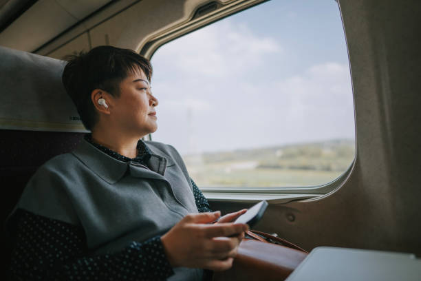 podróże w pojedynkę azjatycka chińska dojrzała kobieta podróżuje szybkim pociągiem do kaohsiung - high speed train audio zdjęcia i obrazy z banku zdjęć