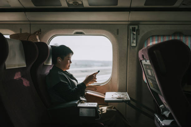 зрелая женщина азиатского происхождения едет на скоростном поезде в гаосюн - high speed train audio стоковые фото и изображения