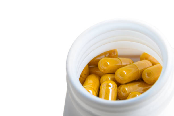 istock turmeric herb capsule, close up image in white background. 1632893170